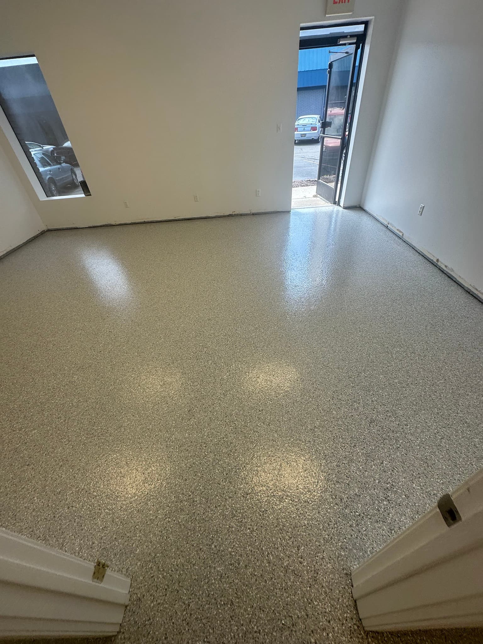 Large empty commercial room with a coated floor