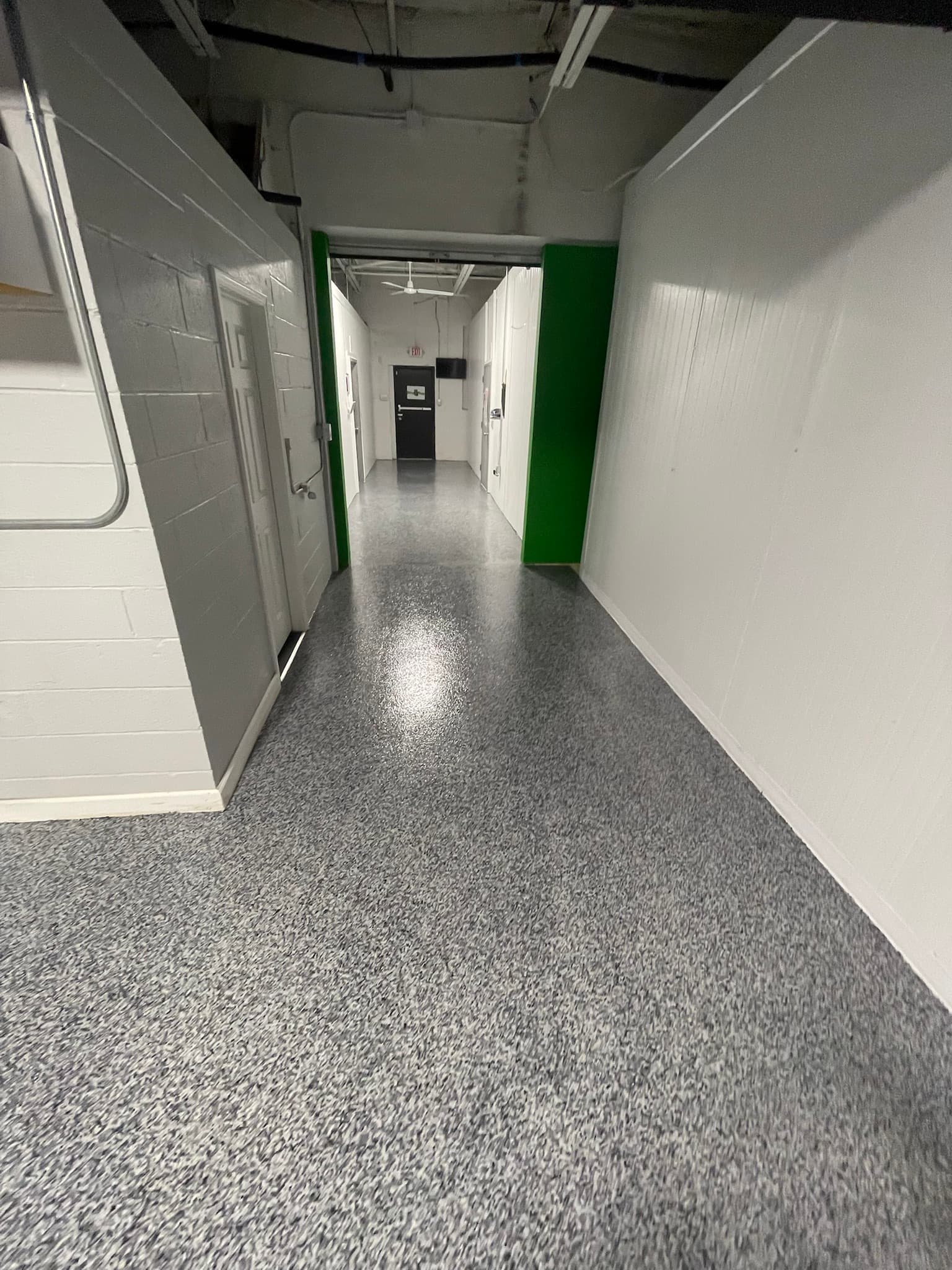 Commercial hallway with a green-accented coated floor