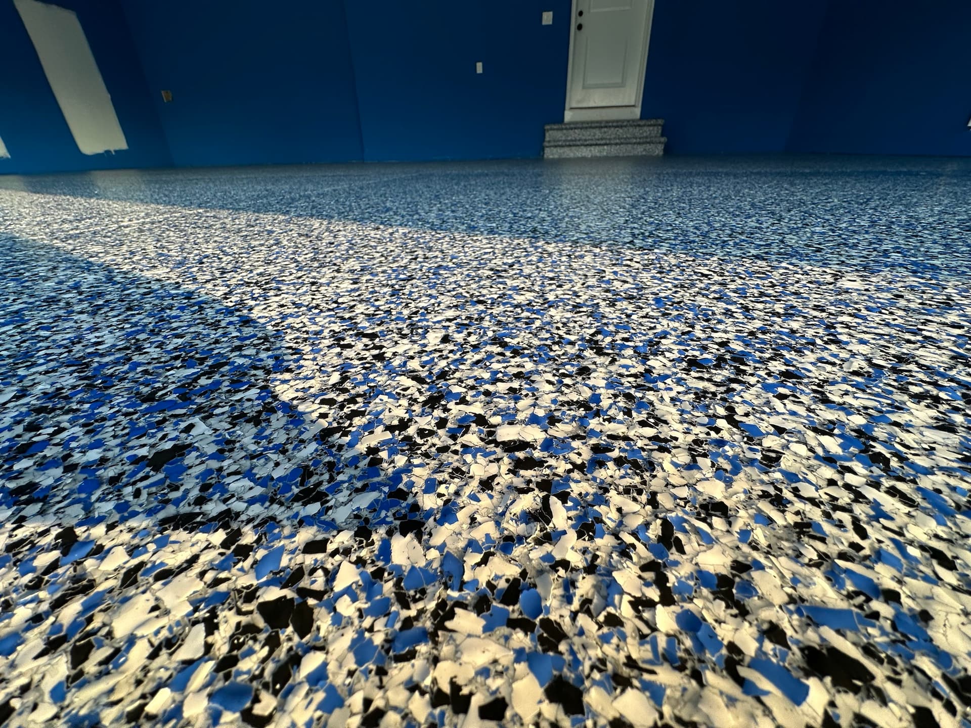 Blue and black flake garage floor with blue walls
