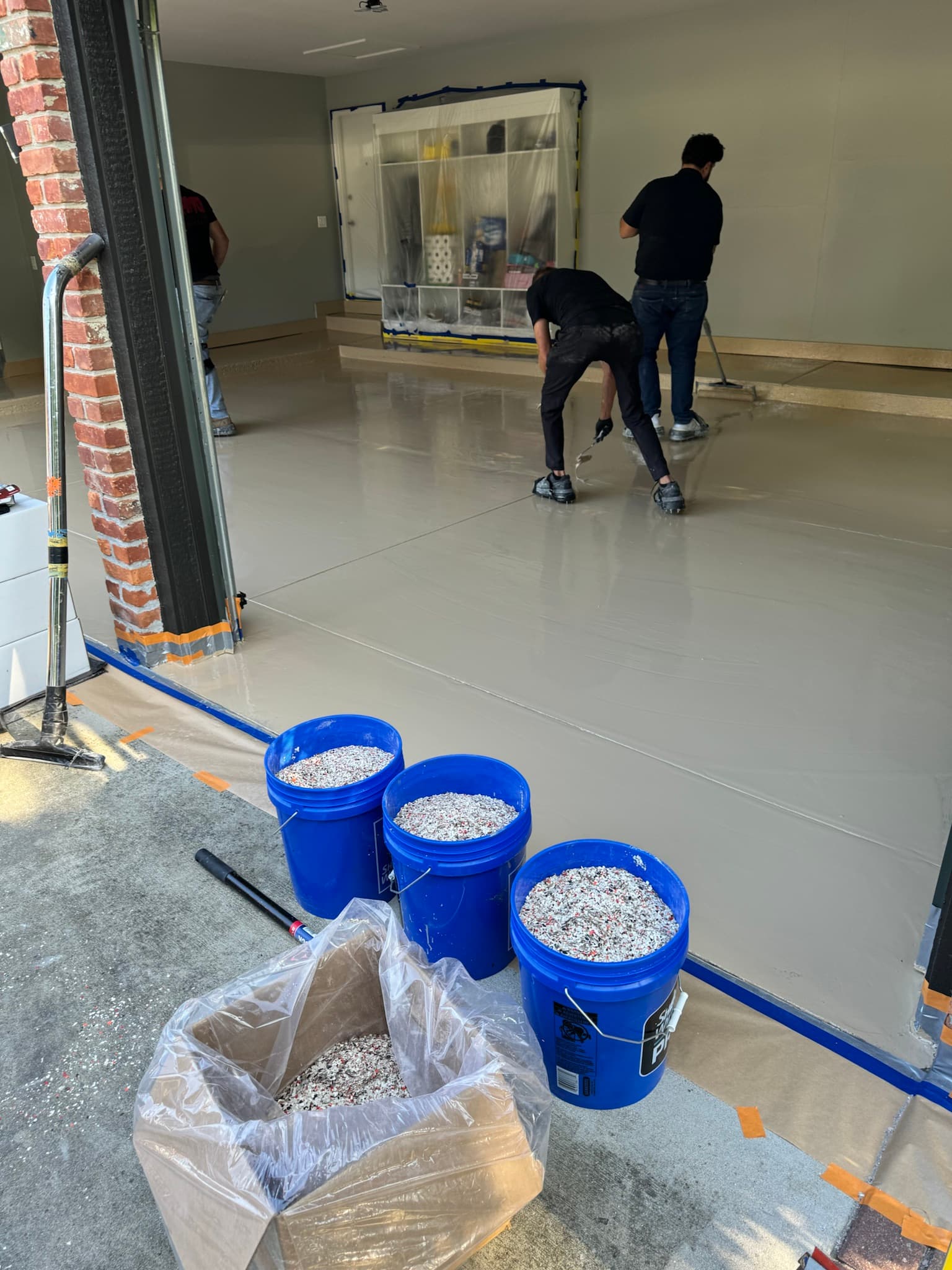 Reserve crew applying epoxy base coat in a residential garage